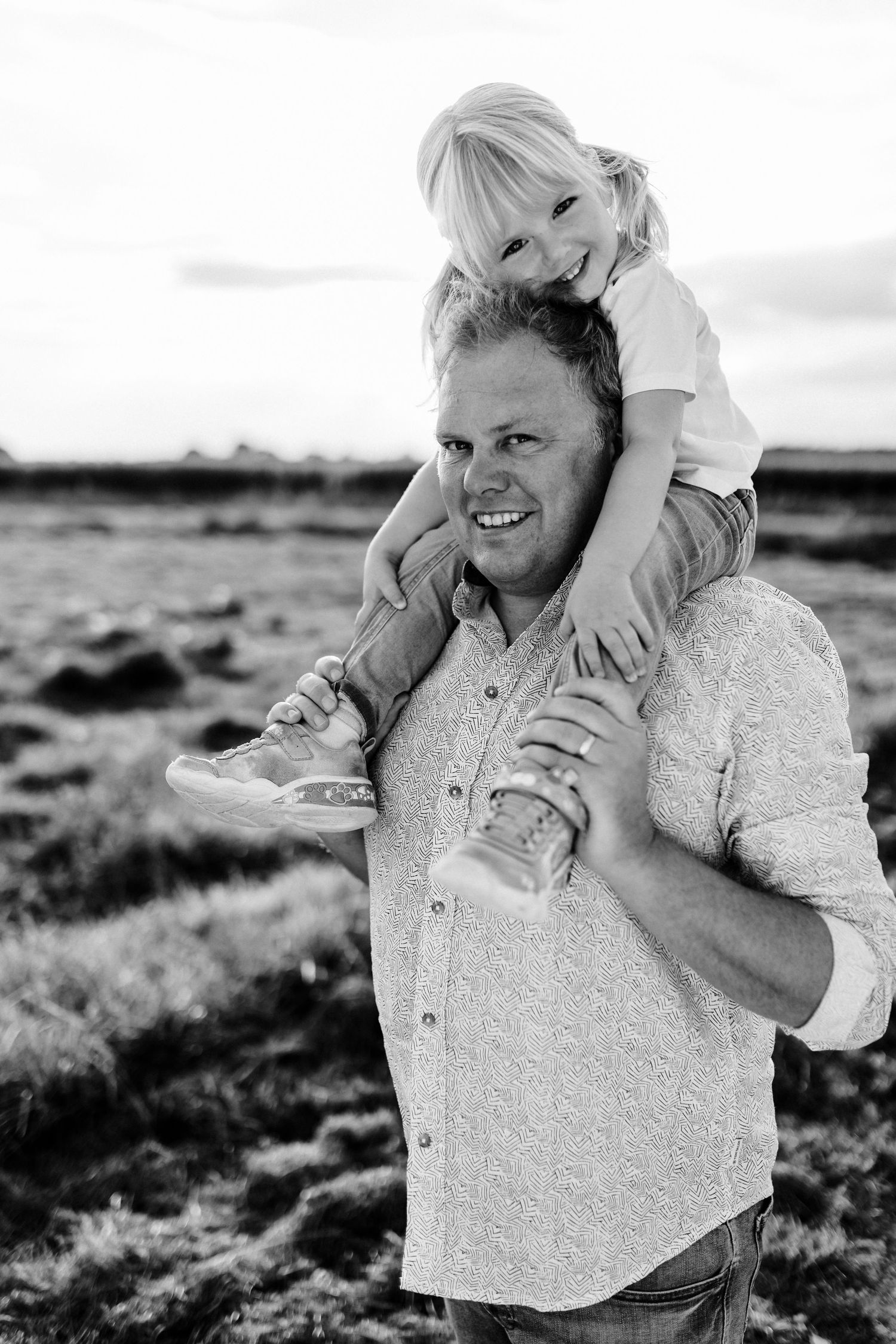 Black and white portrait capturing a playful moment outdoors.