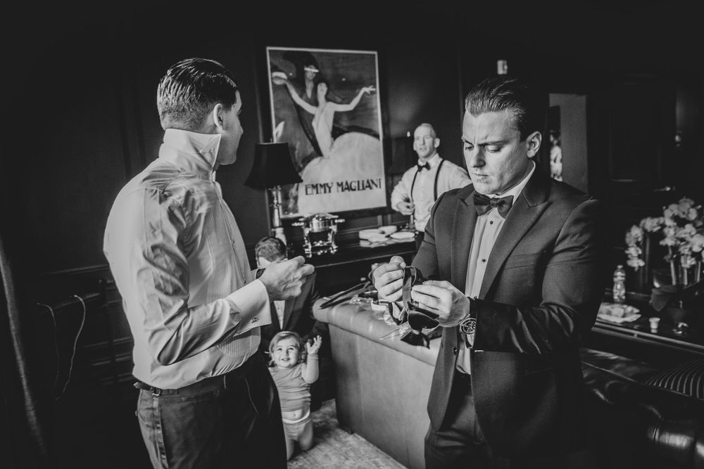 Wedding party members at bar preparing drinks during reception celebration.