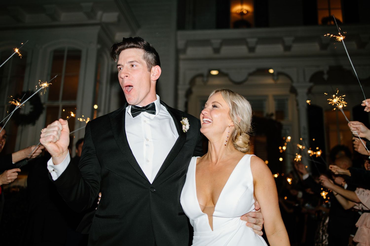 Wedding celebration at night with sparklers and formal attire.