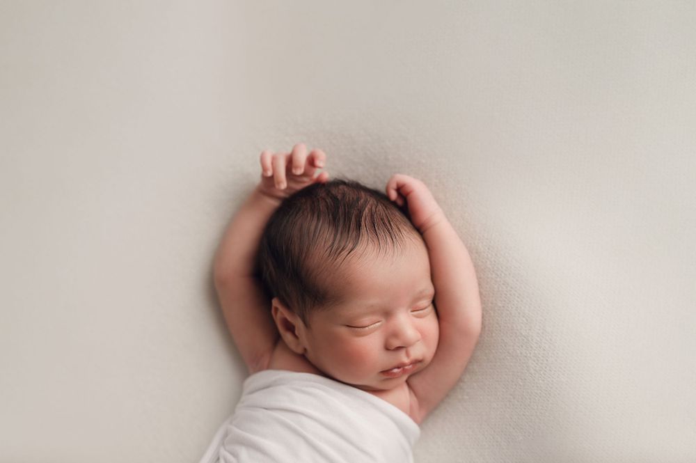 Cute baby boy stretching. Natural newborn photographer pittsburgh.