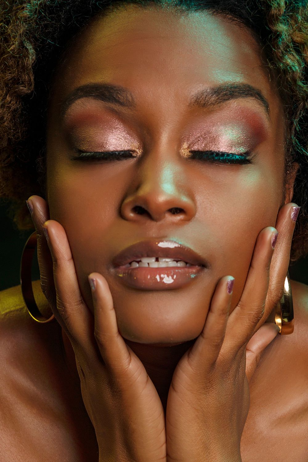 Close-up beauty shot with shimmering turquoise eyeshadow and glossy lips.