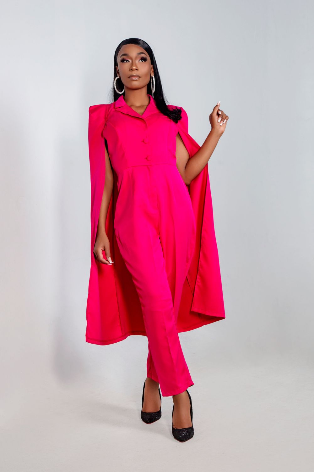 Fashion shots of hot pink cape dress with dramatic shoulders against white background.