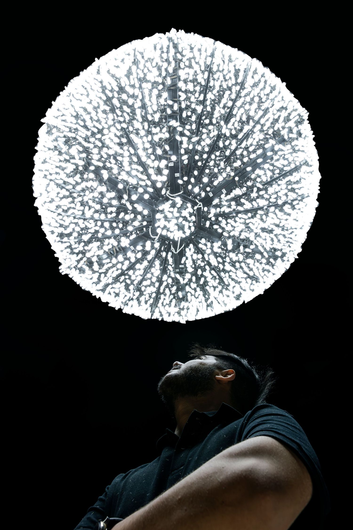 Dramatic spherical light installation creating stark contrast against dark background.