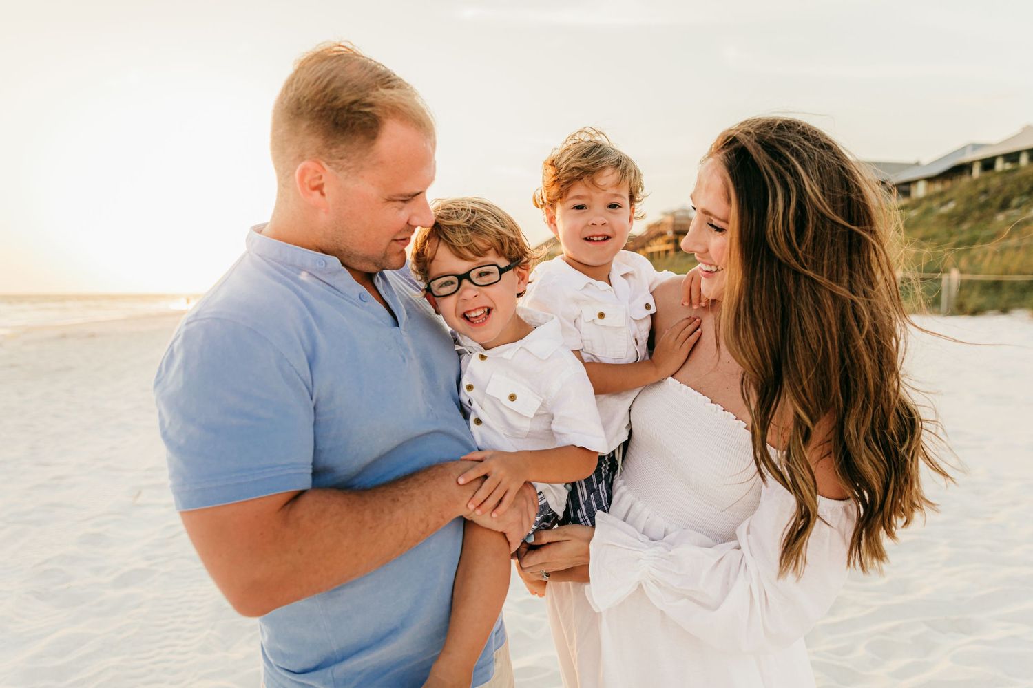 Intimate family moments captured on a white sandy beach during a lifestyle photography session.
