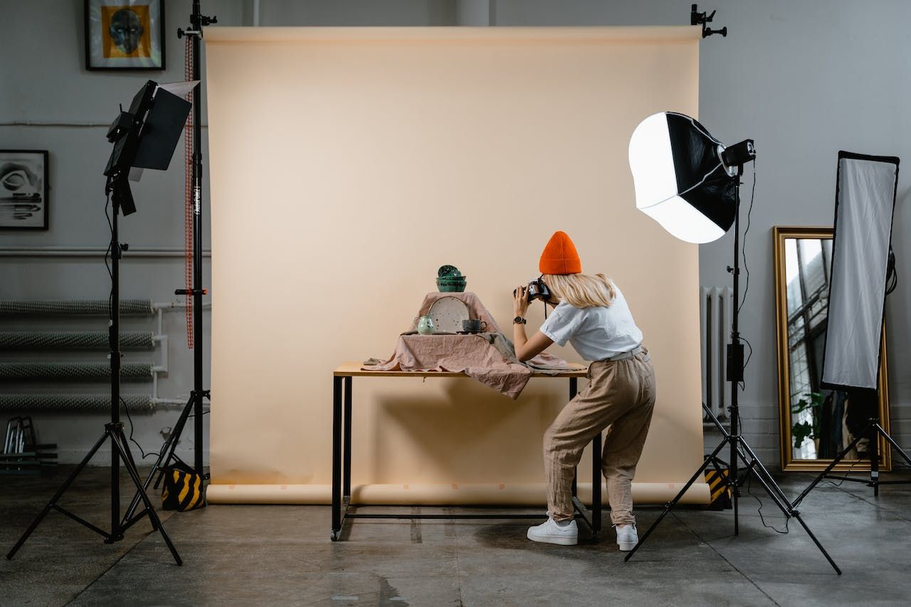 Behind-the-scenes photo studio setup with lighting equipment and backdrop for product photography session.