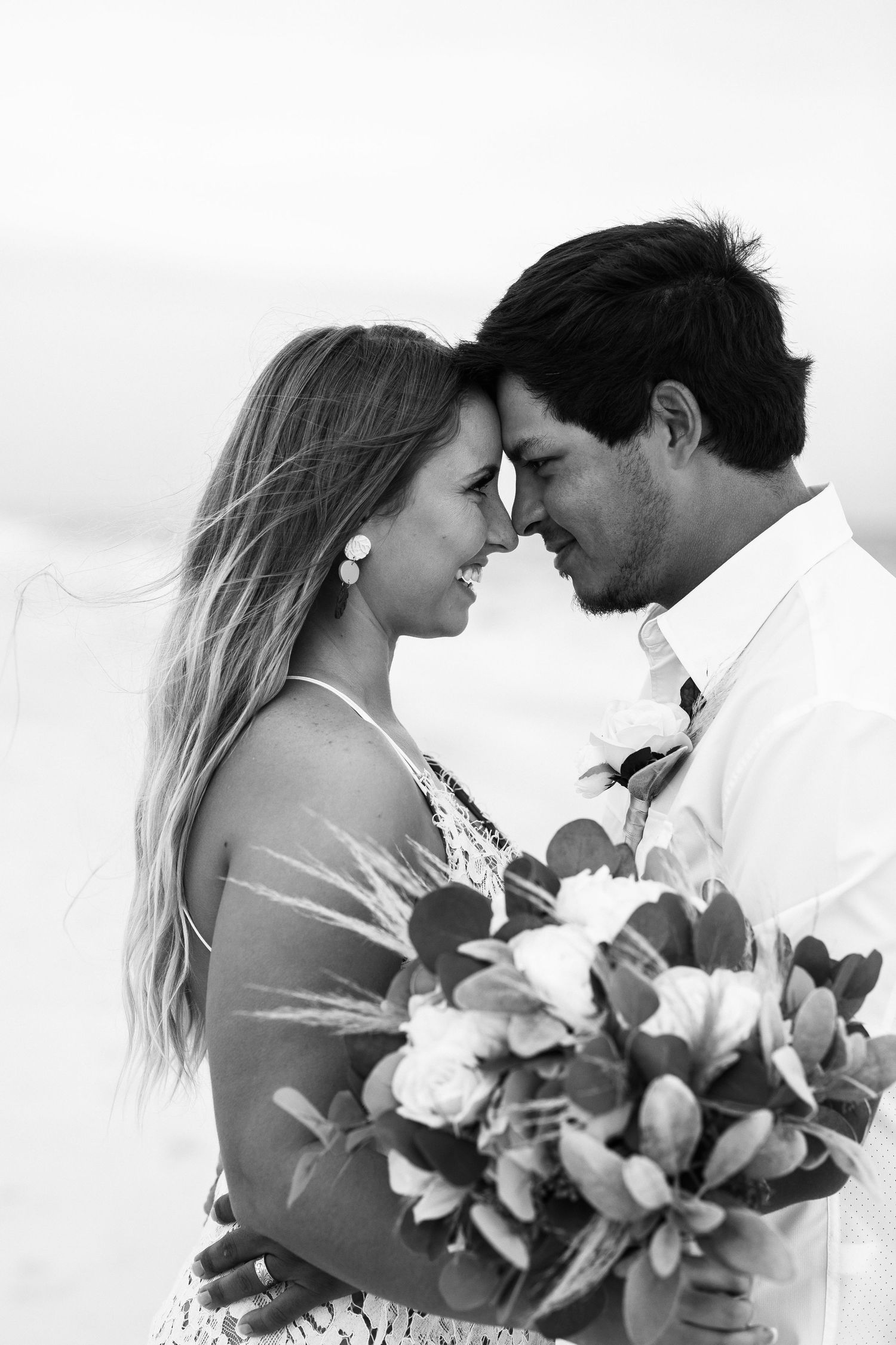 A close-up black and white photo of a romantic moment with a bouquet of flowers.