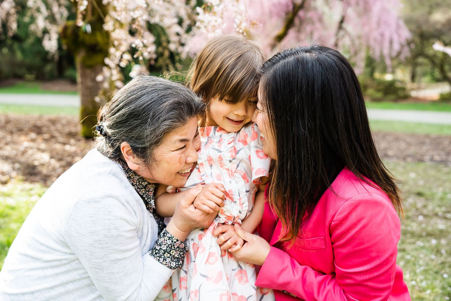 Grandmother, mother and daughter hug each other in the spring