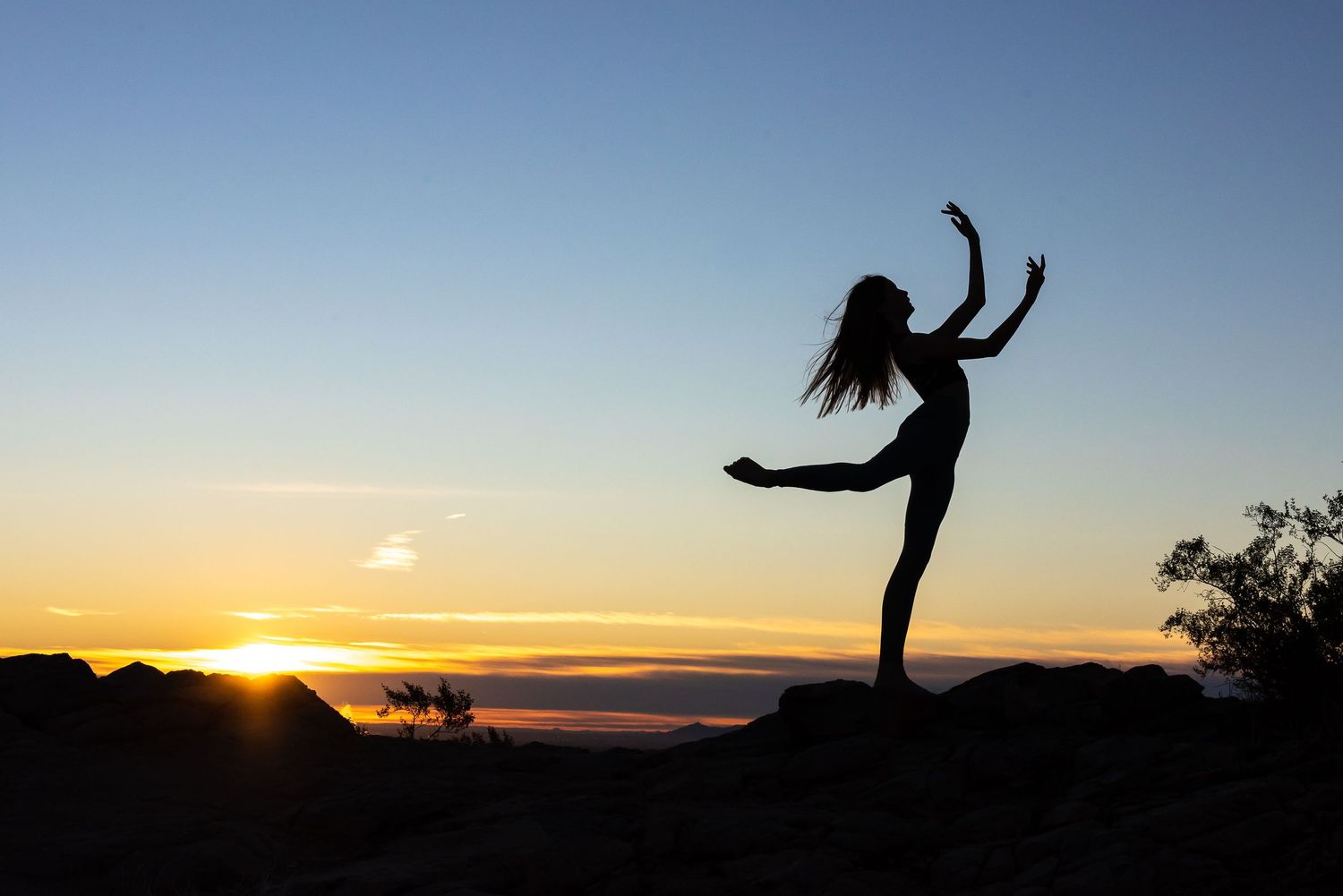 A dancer silhouetted against the sunrise
