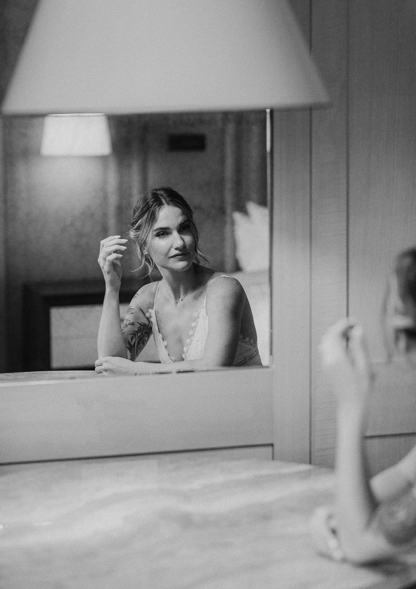 Bridal portrait with a film vibe of bride looking in mirror