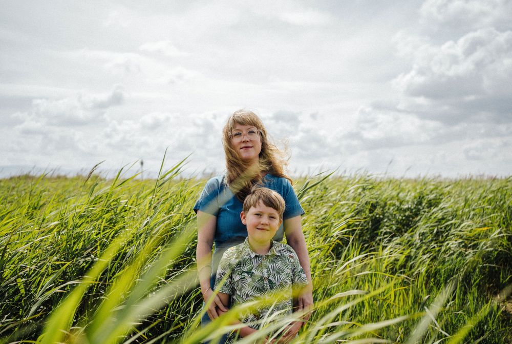 Two people enjoying a sunny day in a tall grass field.