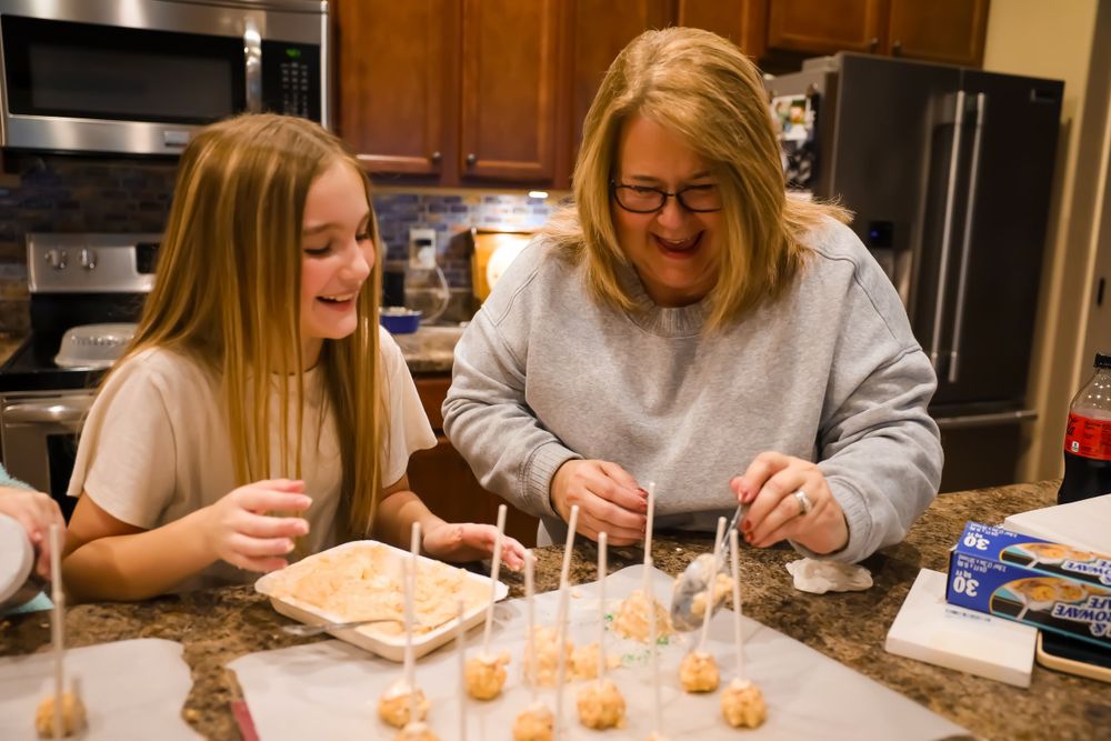Family members decorating cookies together at a kitchen counter.