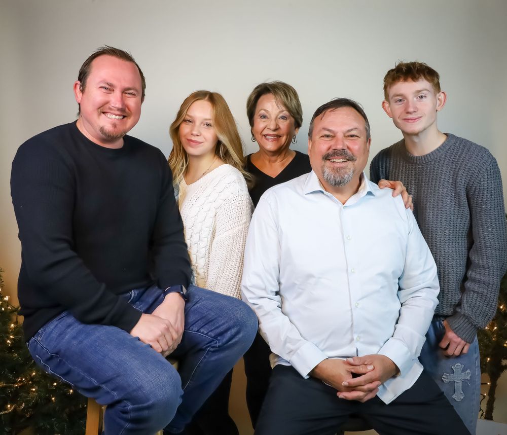 Family members arranged for a formal group portrait against a light background.