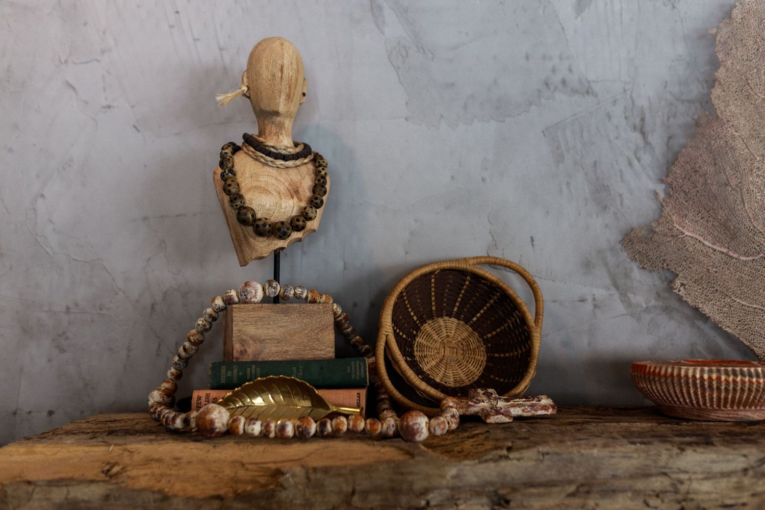 Vintage display with beaded necklaces and decorative woven baskets on rustic wooden surface.