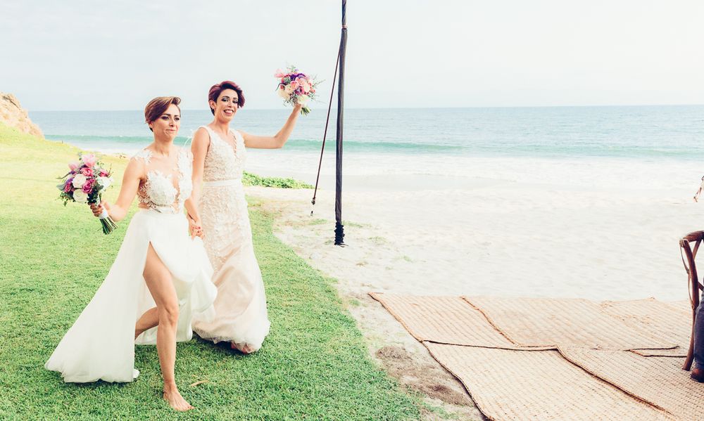 Wedding celebration on beachfront lawn with joyful movement and dancing.