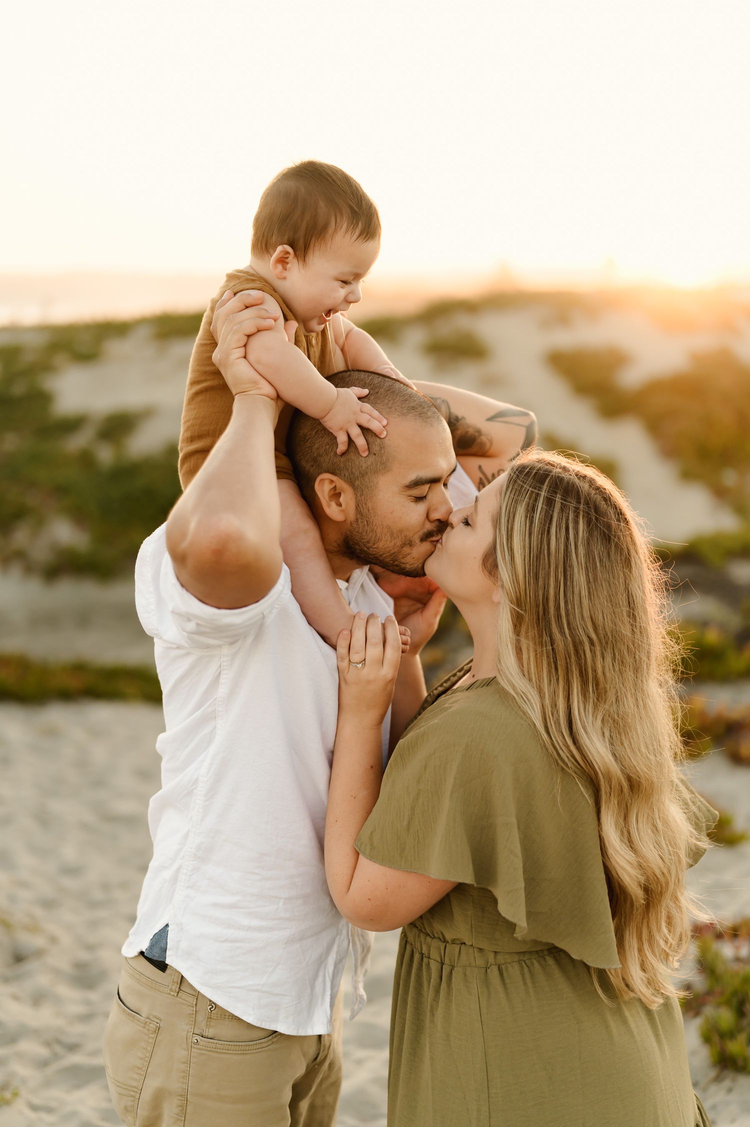 Coronado Beach family photoshoot by San Diego family photographer, Tiffany Kelterer, of couple kissing at sunset