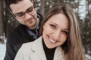 A close-up winter portrait of a couple sharing an intimate moment in the snow.
