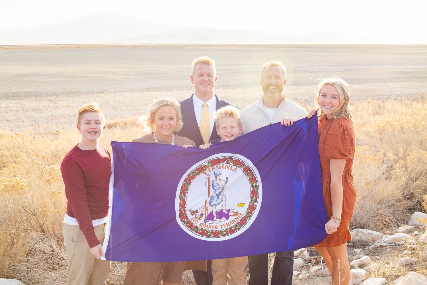A missionary and his family holding a state flag