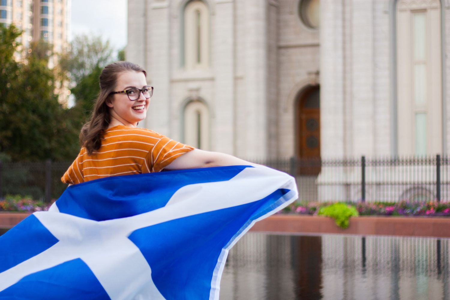 A sister missionary holding a country's flag