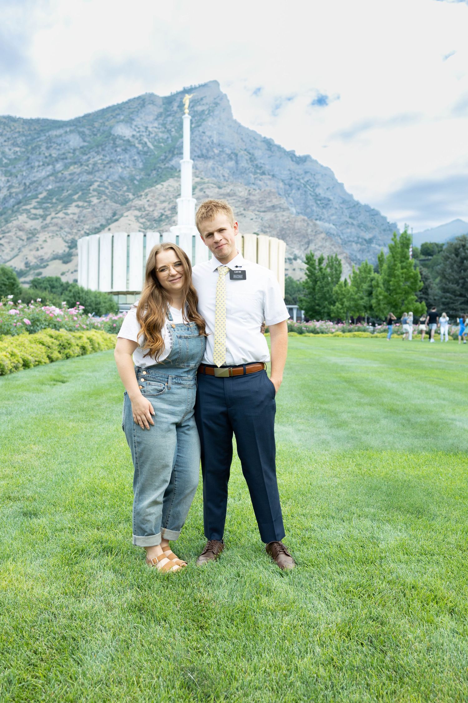 A missionary and his sister in front of the temple in Provo
