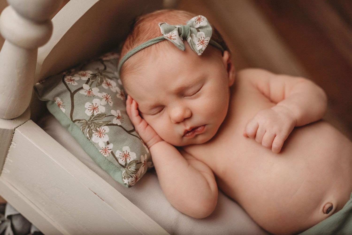 Tampa Newborn Photographer- Baby with green headband on baby bed