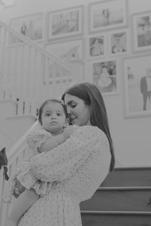 Black and white sequence of tender moments near white gallery wall with framed photos.