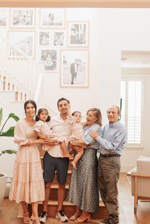 Family gathering photos showing multiple generations posing together near staircase.