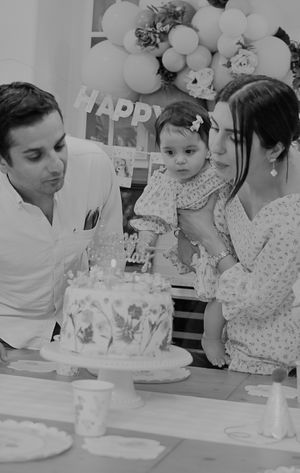 Birthday celebration scene with cake and balloons in black and white photography.