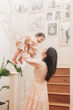 Joy-filled moments captured near white staircase with photo gallery wall.