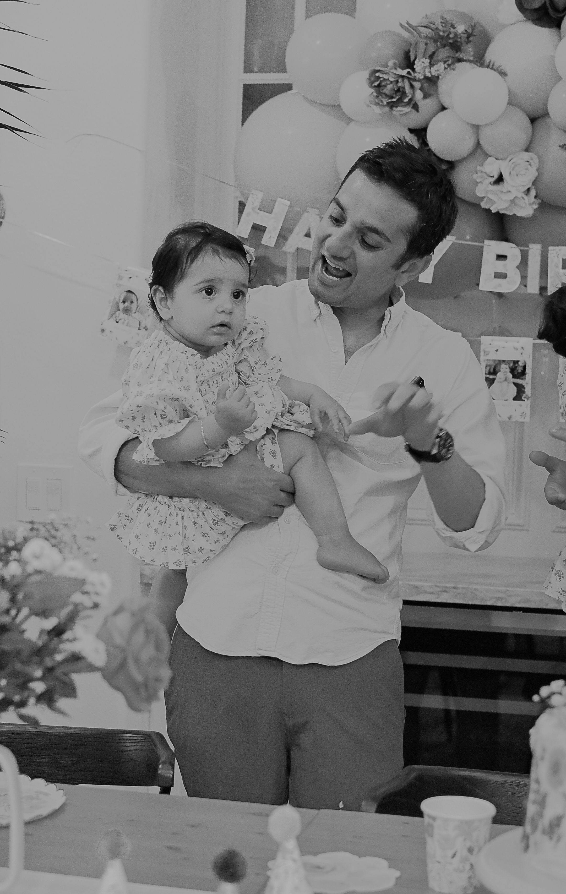 Black and white photo of a birthday celebration with cake and decorations.