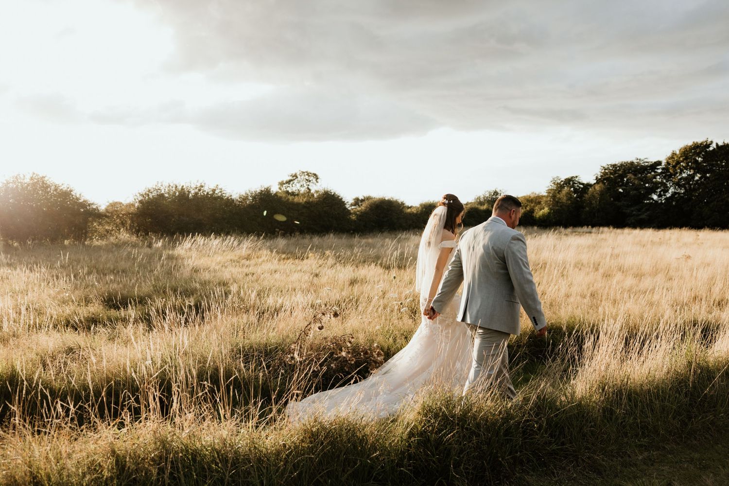 walking through long grass holding hands