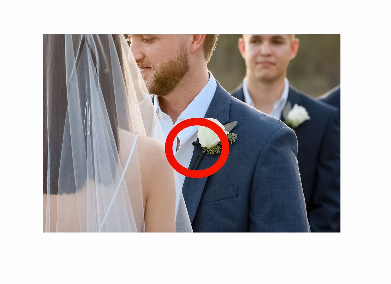 Close-up detail of a formal wedding ceremony showing the bride's veil and groom's navy suit.