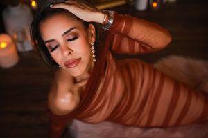 Artistic boudoir photography with warm lighting and dramatic shadows. Beautiful makeup with a long brown mesh dress