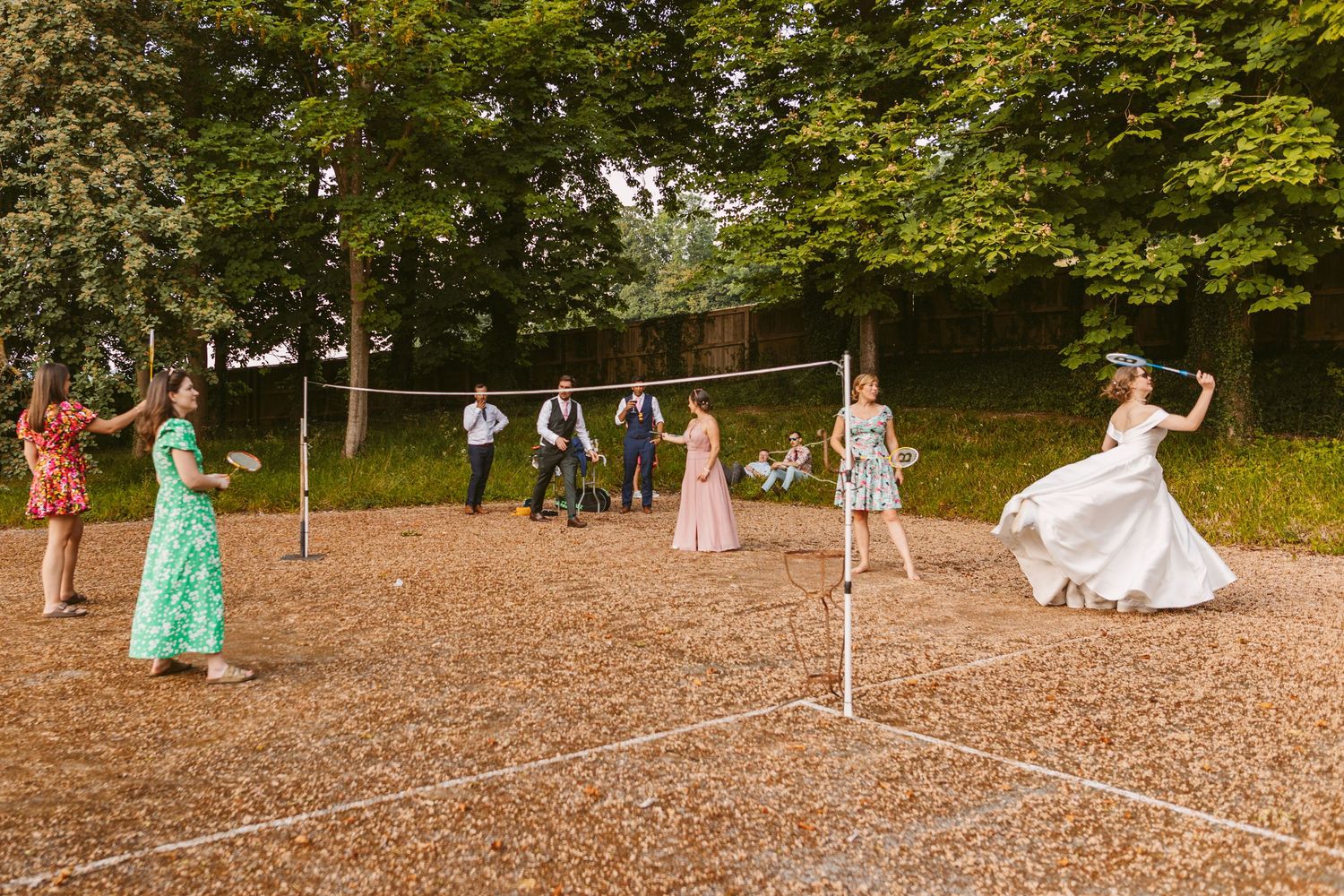 Bride playing badminton in wedding gown