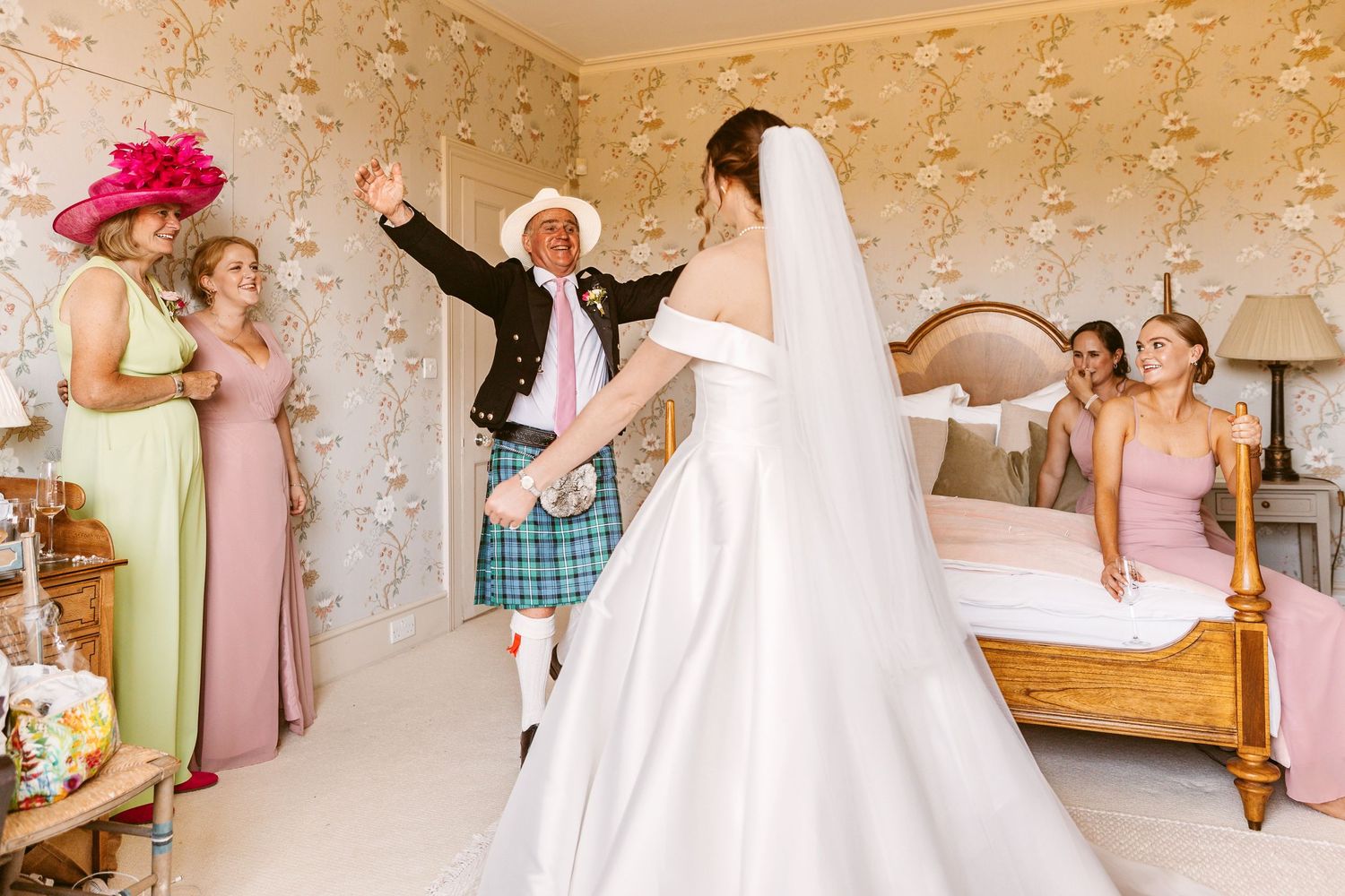 First look Dad wearing a kilt enters and shrieks with joy seeing his beautiful daughter fully ready for wedding
