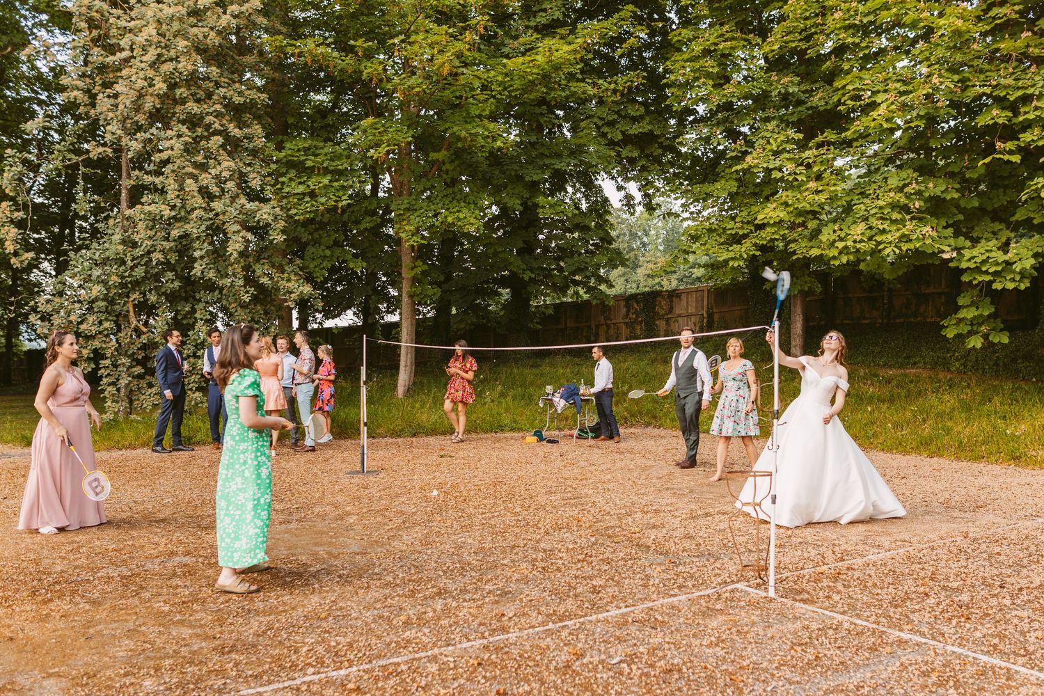 Bride playing badminton in wedding gown at Remenham Court