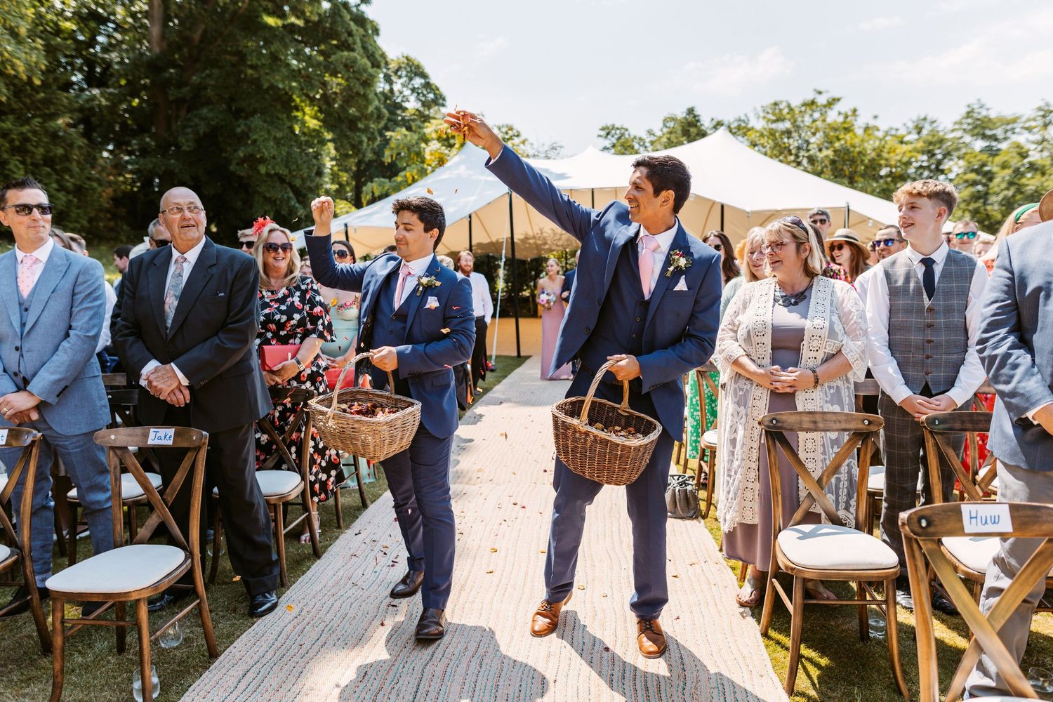Groomsmen as flower girls sprinkling flower petals as they walk up the aisle