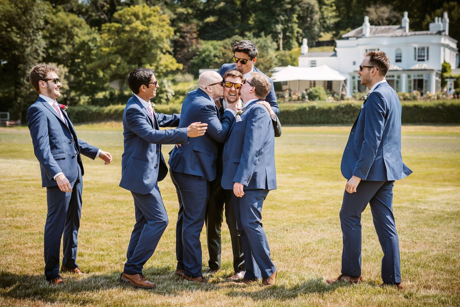 Groom and Groomsmen arriving at wedding venue having a fun moment