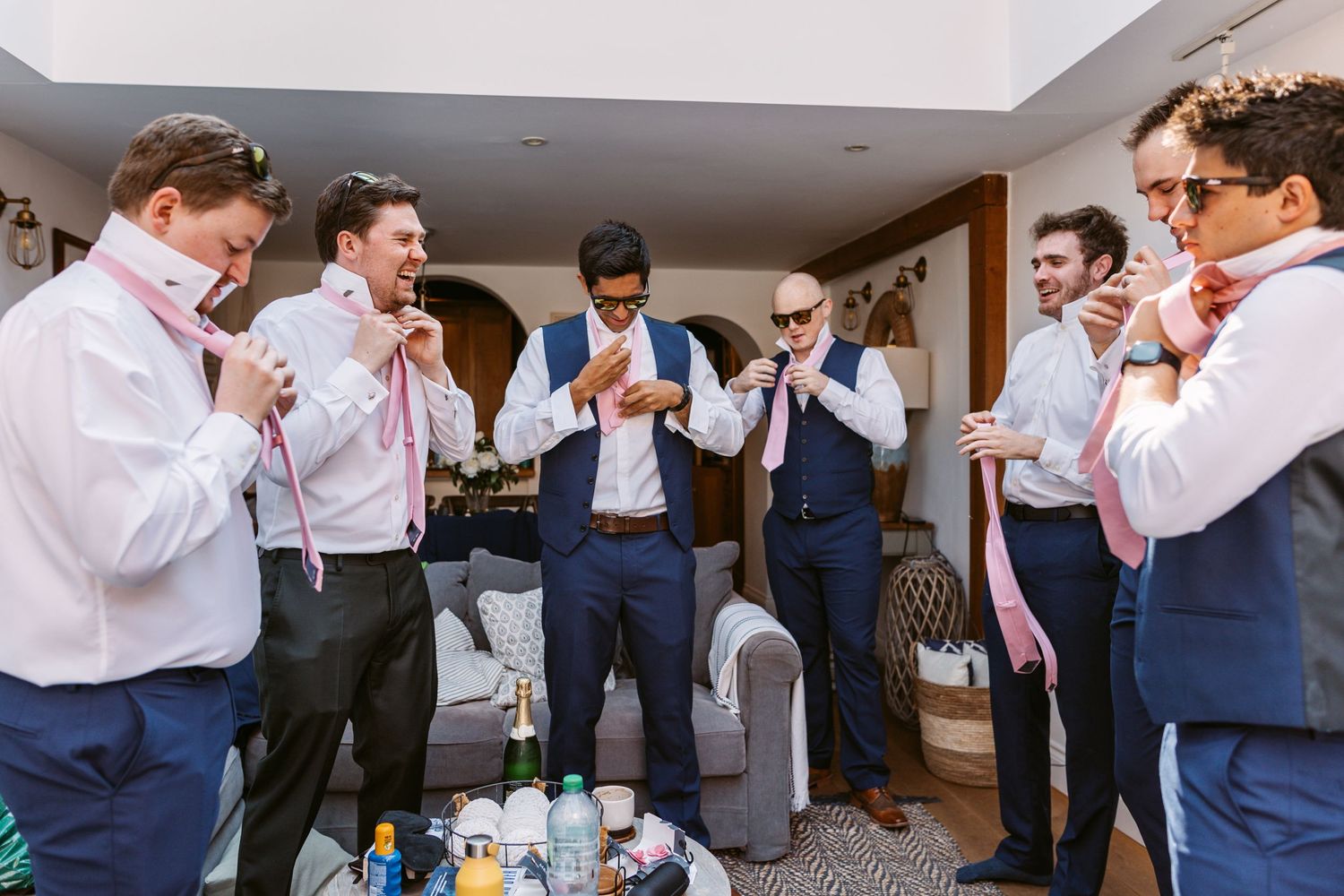 The boys getting ready Groom and groomsmen putting on their ties and laughing