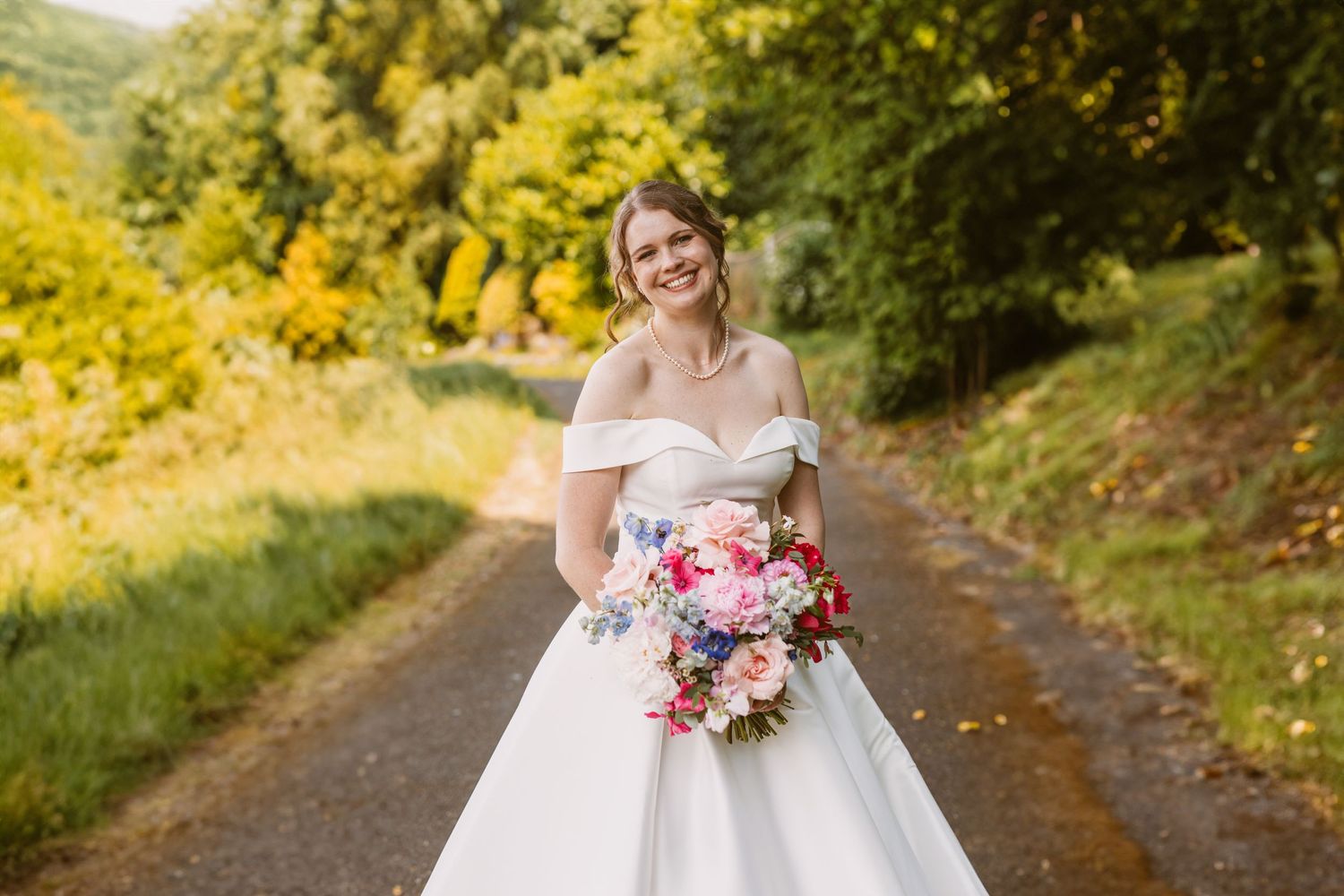 beautiful bride holding bouquet smiling at Remenham Court summer wedding before Royal Regatta