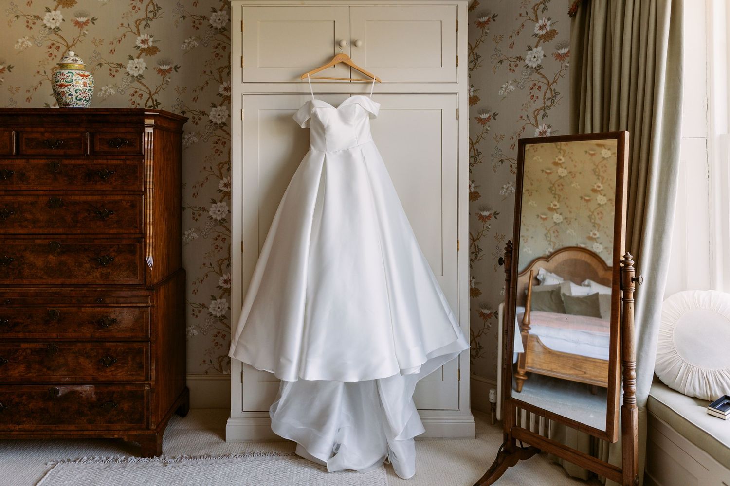 Brides beautiful dress hanging up on wardrobe door in the stunning Remenham Court wedding and events venue