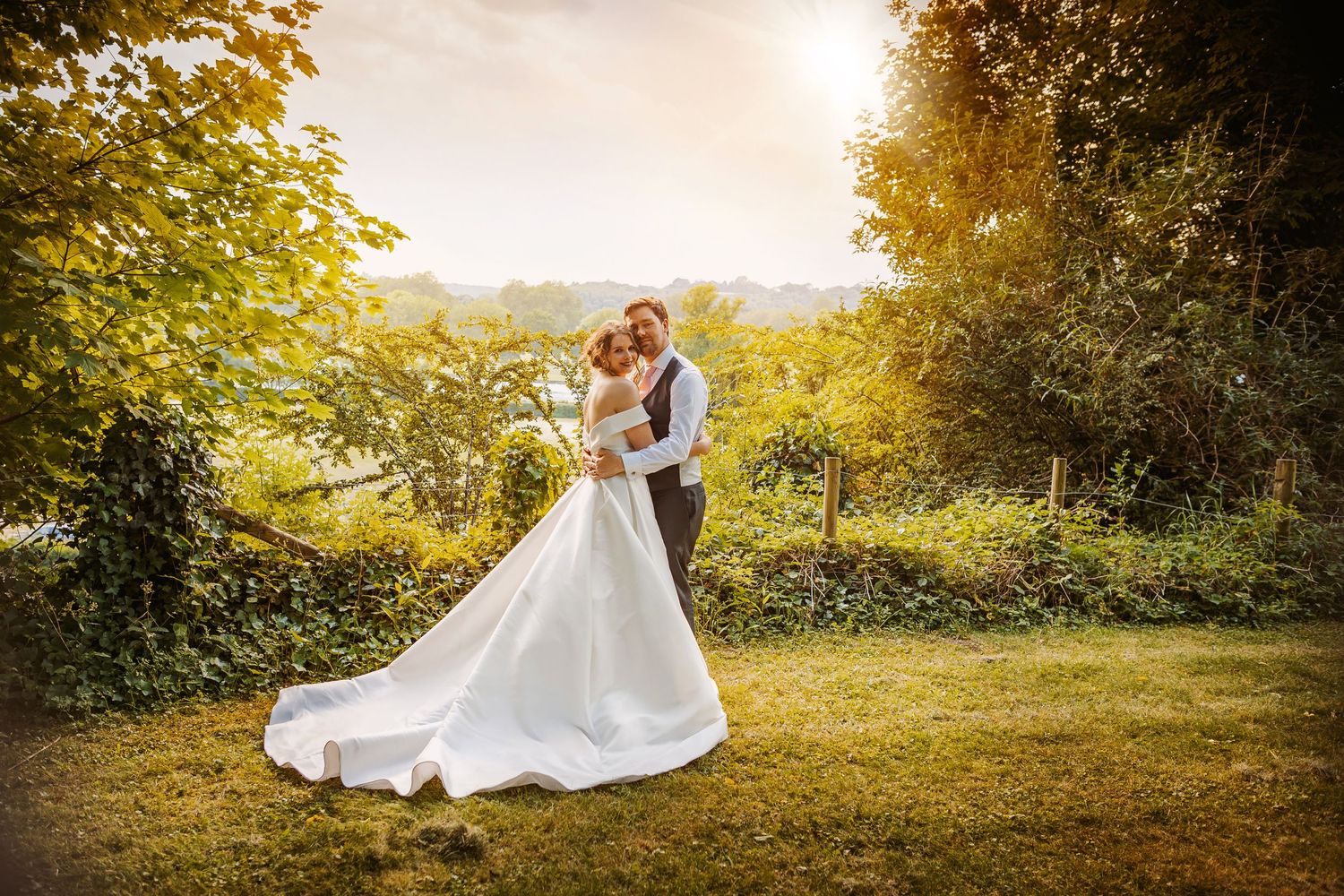 bride and groom embrace in Incredible sunset over the river Thames at Remenham Court with amazing views across Henley