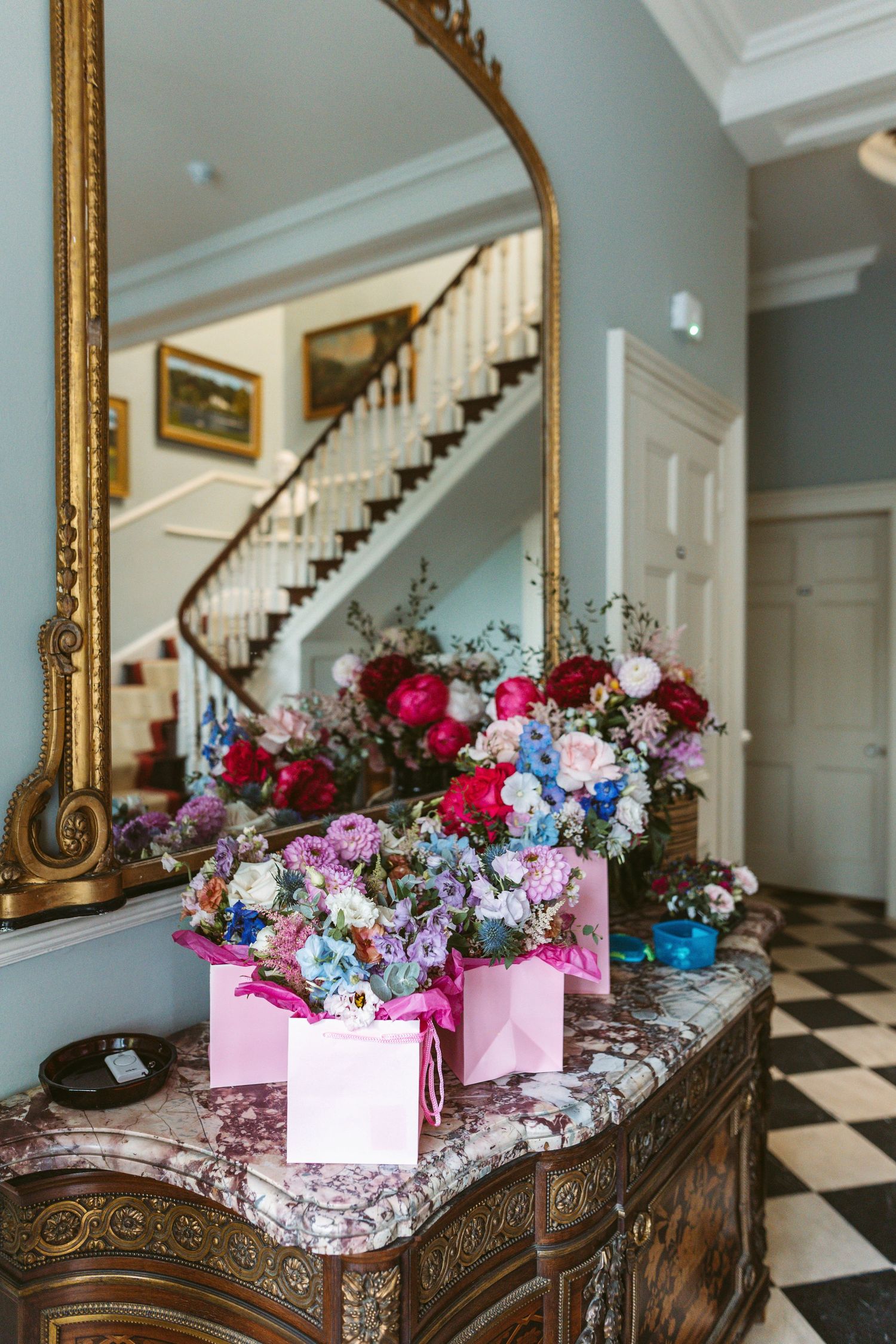 Grand hall way of Remenham Court with beautiful vibrant coloured bouquets