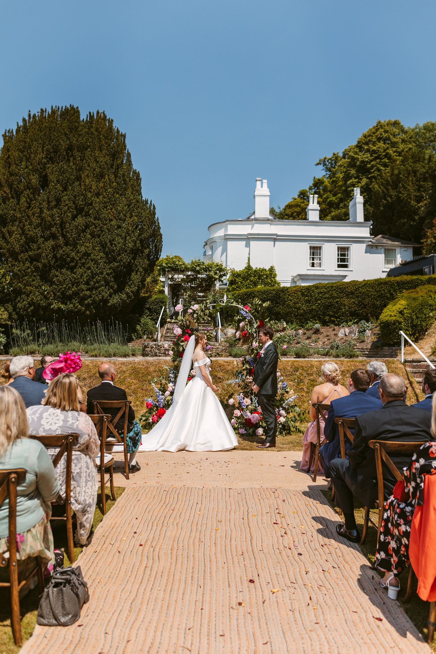 Incredible wedding venue Remenham Court on hot summers day with blue sky above white house