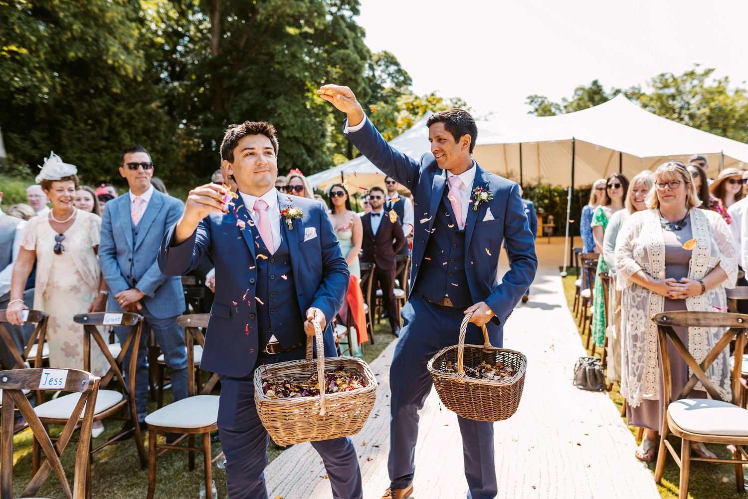 Groomsmen as flower girls sprinkling flower petals as they walk up the aisle