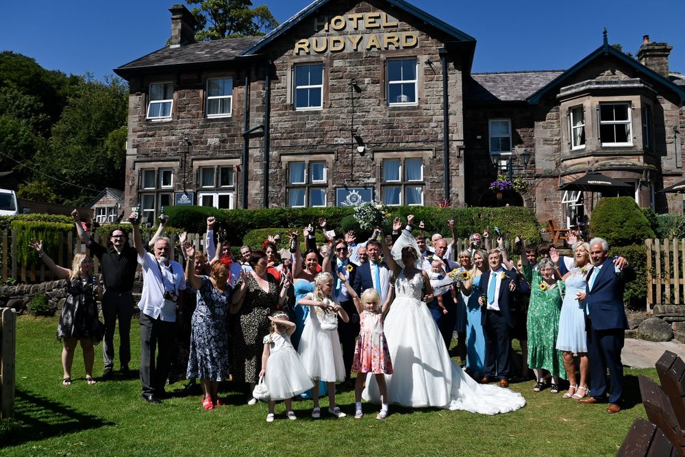 Large wedding party group photo in front of stone country estate building.