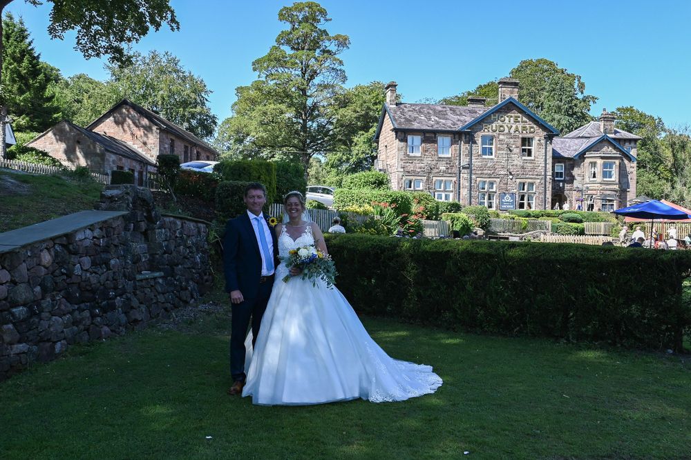 A scenic wedding venue with stone buildings and lush green landscaping in natural daylight.