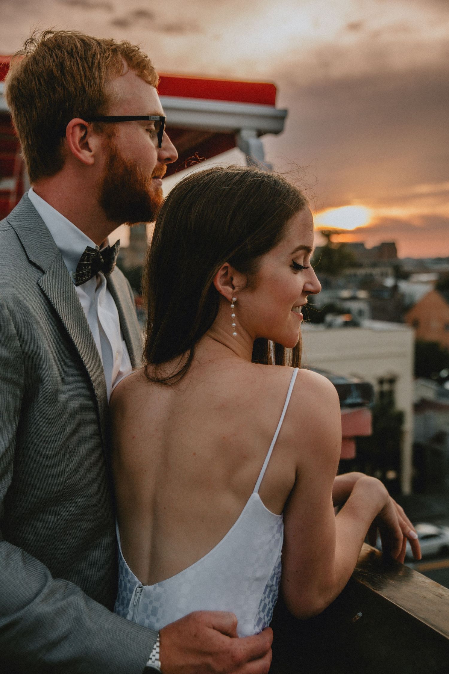 A couple stands on the rooftop of The Venue at sunset