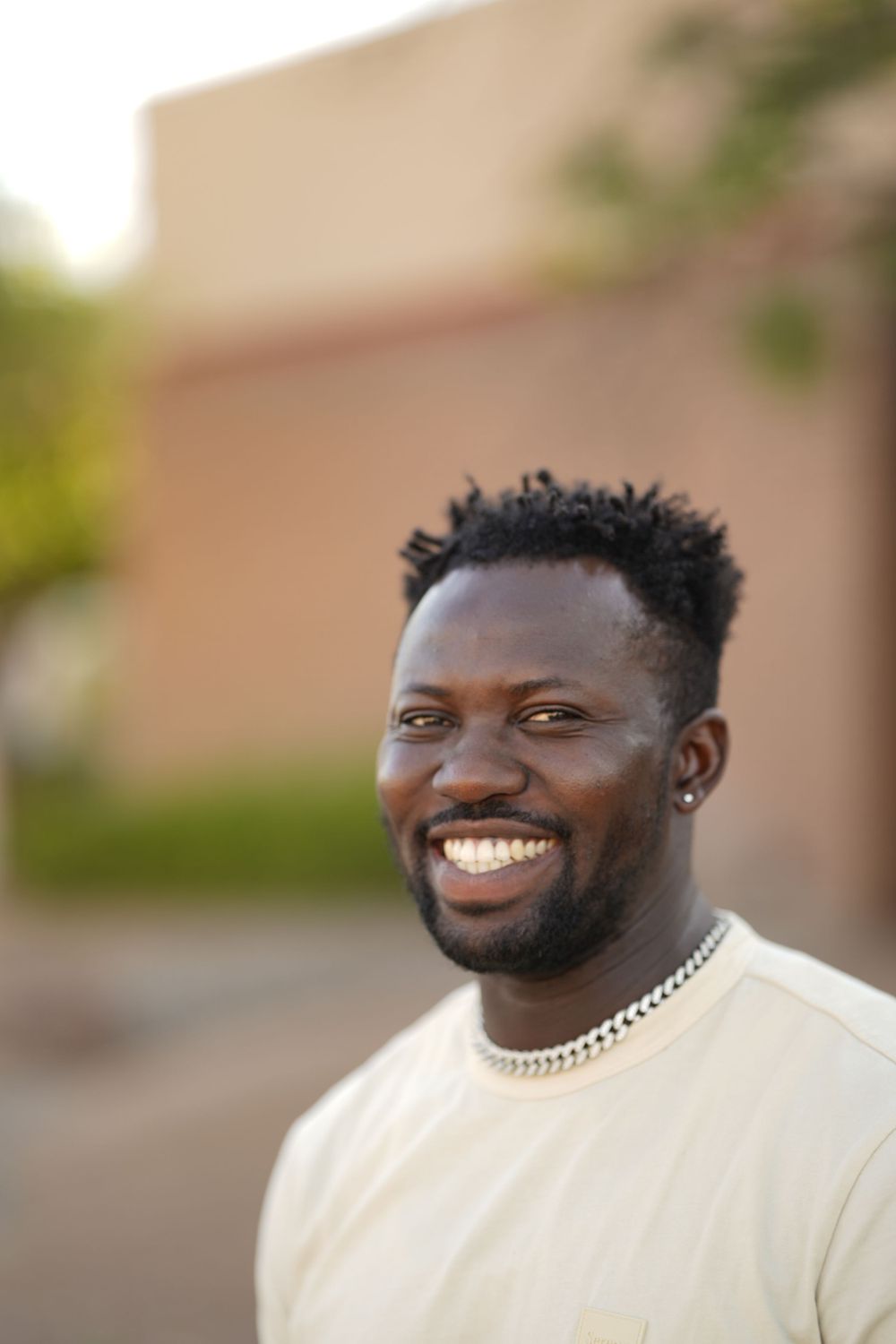 Close-up portrait of person in cream sweater with natural lighting and warm background.