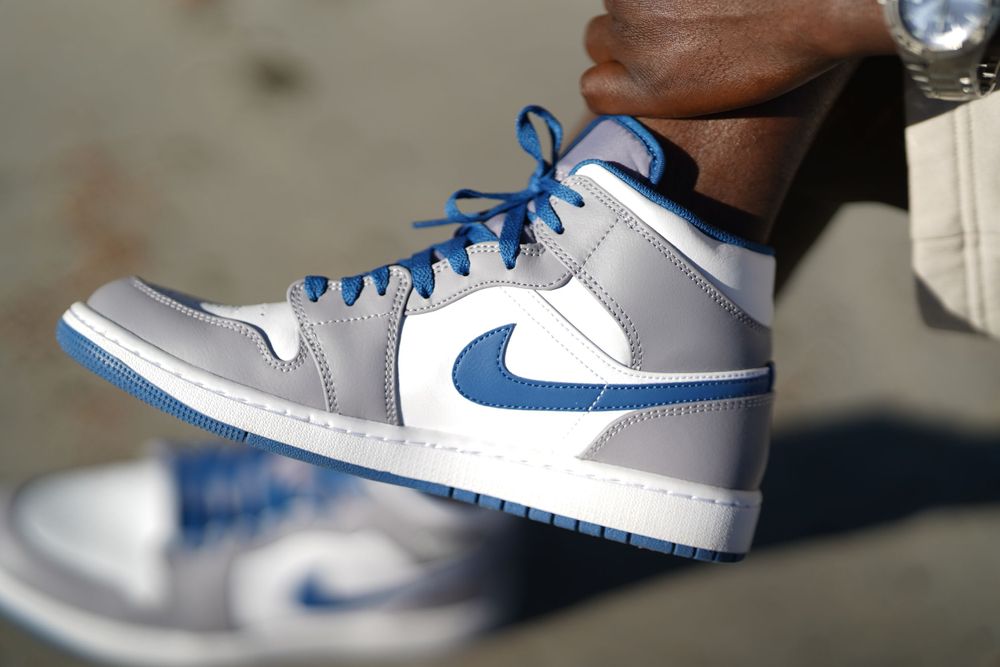 Close-up of Nike Air Jordan mid-top sneaker in white, grey and blue colorway.