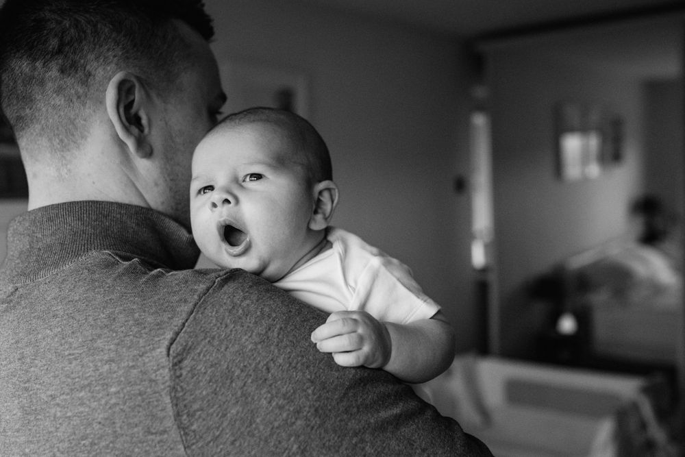 A series of black and white photos showing a baby's emotional expressions and interactions in a hospital setting.